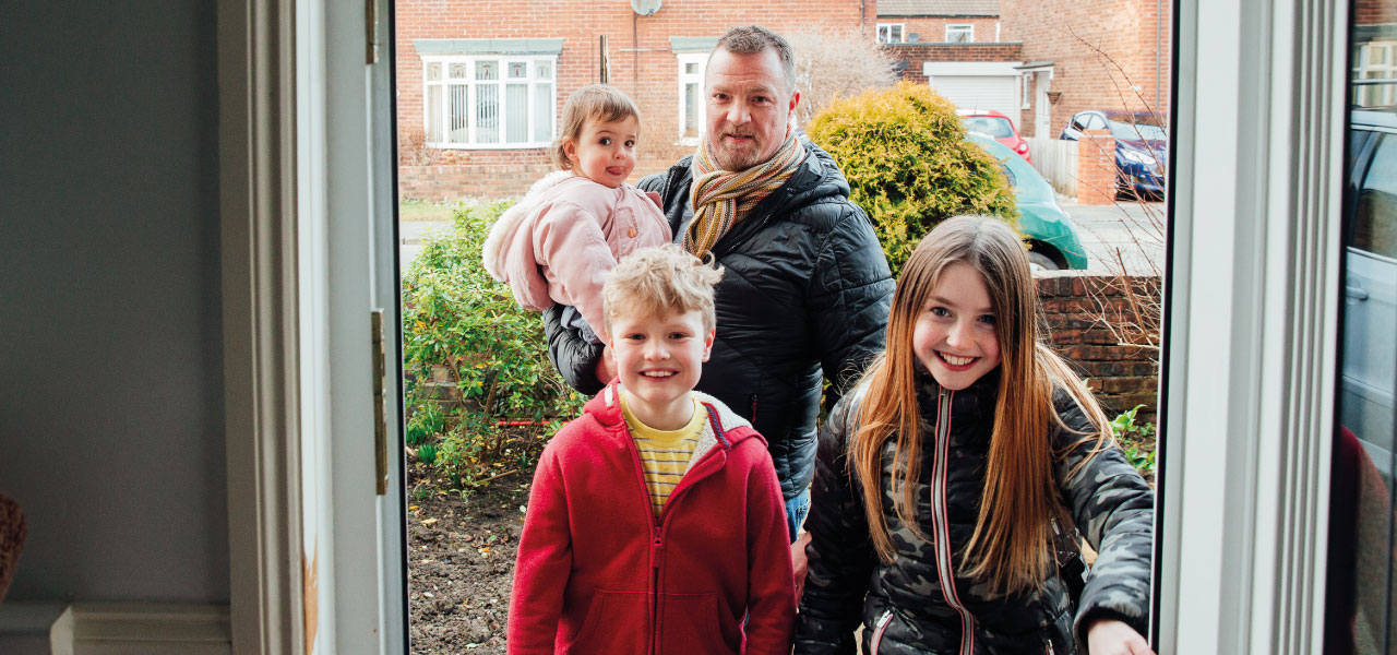 A family walking in the front door of their house